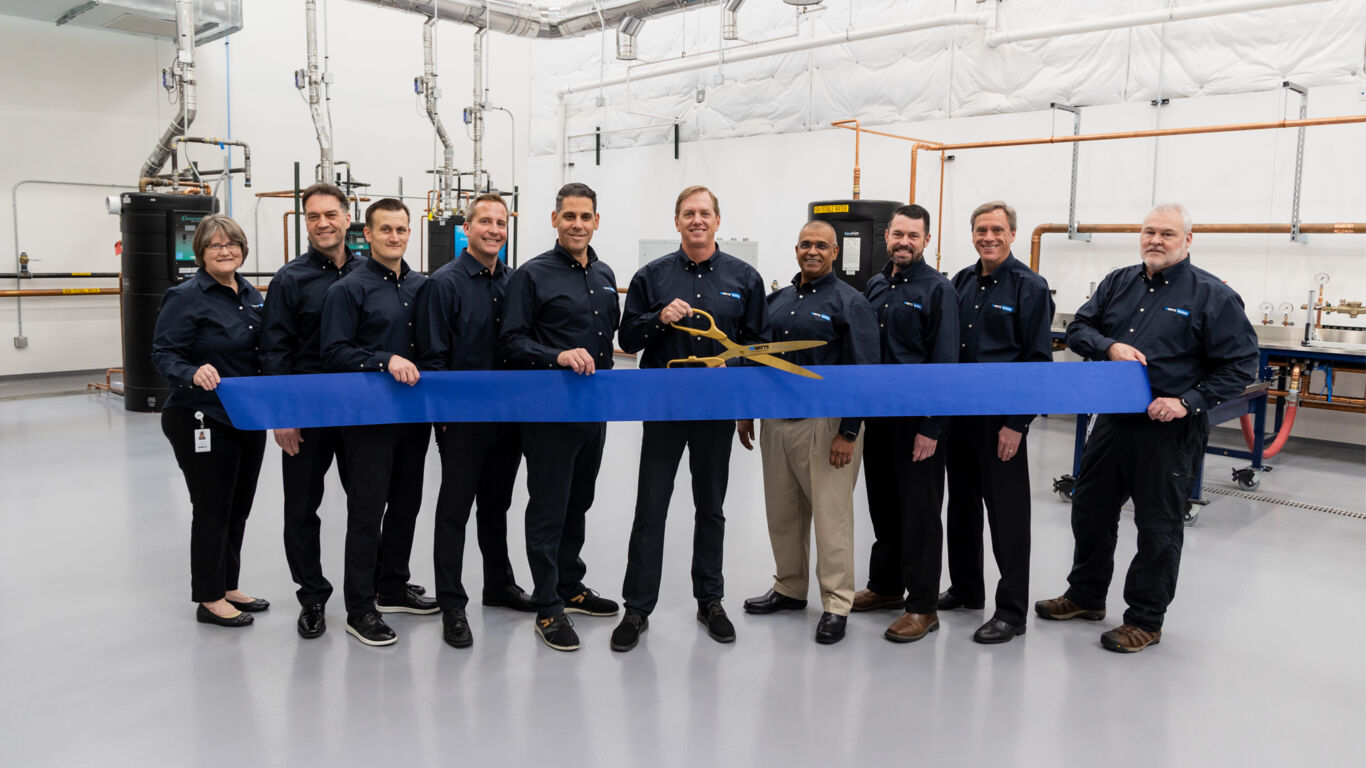 Three manufacturer workers stand in their workplace